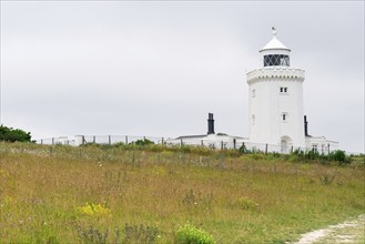 A lighthouse overlooks a natural landscape under a cloudy sky, South Foreland Lighthouse, White