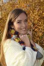 Portrait of young beautiful smiling woman, 30 years old, outdoors in forest with autumn colors in