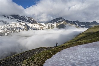 Mountaineer in front of mountain landscape with high fog in the valley, summit Hochfeiler and