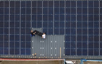 Installation of solar modules on the roof of a barn on a farm, over 210 photovoltaic modules are