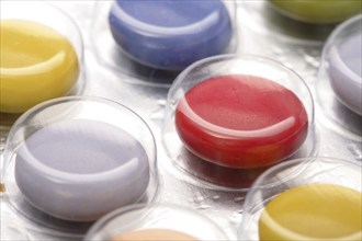 Colourful tablets packed in plastic, tablet addiction, drug addiction, studio