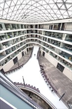 Open interior of a modern office building with glass roof and symmetrical design, University of