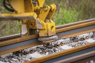 Close-up of a yellow construction machine working on a rail, track construction, Hermann Hessebahn,