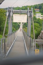 Suspension bridge with people and banner, surrounded by dense forest, Rappbodetalsperre, Harz