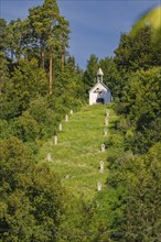 Small chapel on a wooded hill with several graves. Peaceful nature in the background, Gundringen,