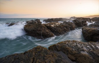 Waves washing over rocks by the sea, long exposure, coastal landscape at sunset, Playa Cocalito,