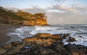 Sandy beach beach with rocks and sea at sunset, Playa Cocalito, coastal landscape, Pacific coast,