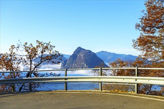 Mountain Peak San Salvatore Above Cloudscape and Mountain Road with Sunlight and Clear Sky in