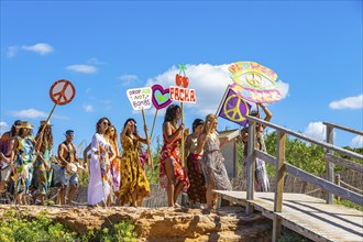 Colourfully dressed youths with musical instruments and banners form a love parade and promote the