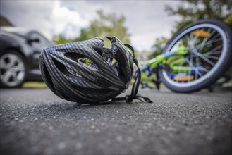 Symbol photo on the subject of bicycle accidents (posed scene) . A broken bicycle helmet lies next