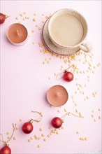 Christmas or New Year composition. Decorations, red balls, cup of coffee, on a pink paper