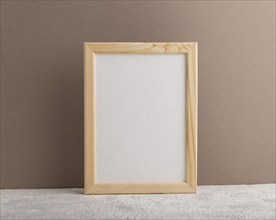 White wooden frame mockup on beige paper background. Blank, vertical orientation, still life, copy