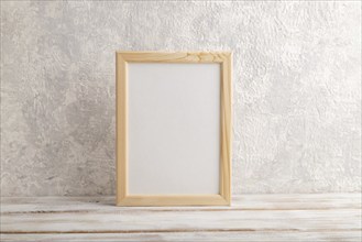 White wooden frame mockup on gray concrete background. Blank, vertical orientation, still life,