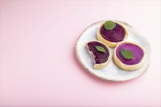 Sweet tartlets with jelly and milk cream on a pastel pink background. Side view, copy space