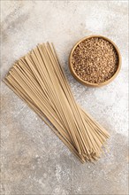 Japanese buckwheat soba noodles with tomato, eggs, spices, herbs on brown concrete background. Top