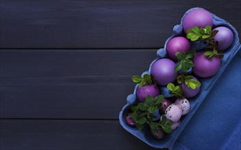 Easter eggs, purple and lilac, on a gray wooden table, Easter card, banner, selective focus,