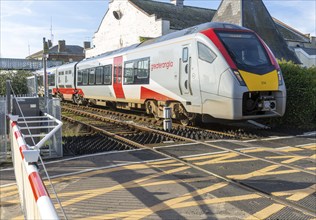 Abellio Greater Anglia Class 755 Stadler bi-modal train at level crossing, Woodbridge, Suffolk,