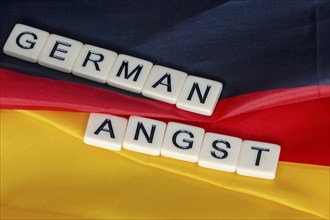 Symbolic image of German Angst: letter cube on a German flag