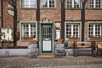 Entrance area of a restaurant in a historic half-timbered brick house with entrance door, white