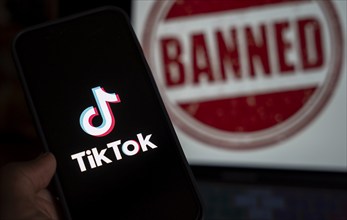 In this photo illustration, logo of Tiktok is displayed on mobile phone screen next to ban sign, in