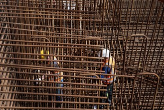 Construction site, reinforced concrete construction site, workers erect a mesh of reinforcing bars,