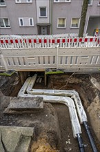 Construction site of a district heating house connection, pipes, insulated, are laid from a central