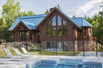 In-ground salt water swimming pool and brown stained milled Eastern white pine timber and flat log