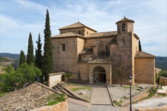 Historic medieval church surrounded by trees and a cobbled path, Parish Church of San Miguel,