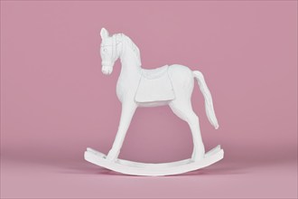 White wooden retro style rocking horse Christmas home decor object on pink background