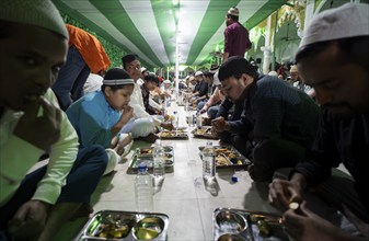 Muslim devotees have 'iftar' meal together to break their fast during the holy month of Ramadan, at