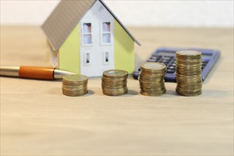 Concept photo with model house and coins