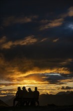 People marvelling at Montafon mountains with dramatic cloudy sky at sunset, Tschagguns, Rätikon,