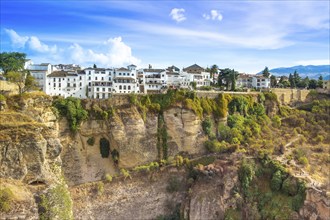 Famous Ronda restaurants and colonial houses overlooking the scenic gorge and the Puente Nuevo