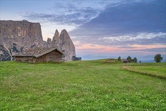 Alpine hut in front of Schlern, sunrise, blue sky with clouds, Seiser Alm, Dolomites, South Tyrol