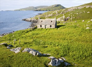 Deserted derelict croft cottage in coastal location on Vatersay Island, Barra, Outer Hebrides,