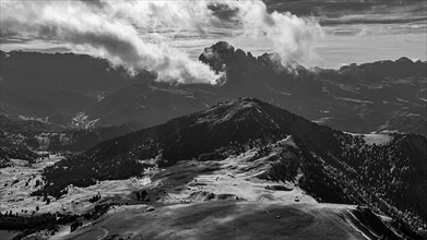 The Picberg, in the background the peaks of the Sassolungo group, shrouded in fog, drone shot,