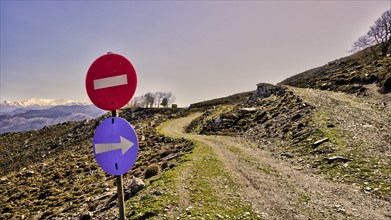 Road signs in front of a fork on a gravel road in the mountains, Lefka Ori, White Mountains,