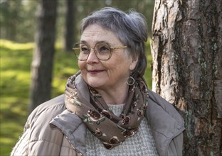 Portrait of elderly woman, 65 years old, enjoying nature in the forest in Ystad, Skåne, Sweden,