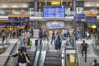 Travellers in the station building with shops and digital display board, Nuremberg Central Station,