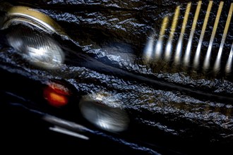 Car Lamps and Car Grille on the Front of a an Old Classic Car Covered with Plastic Protection in