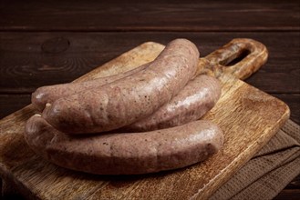 Raw sausages in English with bacon, for grilling, on a cutting board, top view, no people