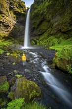 Tourist at Kvernufoss waterfall, in summer when the weather is nice, gorge and river, long