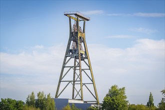 A steel winding tower surrounded by a green landscape and blue sky, Harz Mountains, Germany, Europe