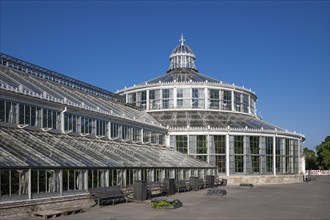 Large historic greenhouse, palm house with glass façade, blue sky, Botanical Garden or Botanisk