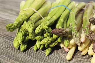 Green asparagus and white asparagus decorated on a rustic wooden table