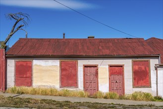 Boarded up house with red roof and red doors, city of Punta Arenas, Patagonia, Chile, South America