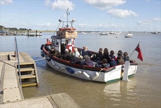 Regardless river cruise boat approaching quay, River Ore, Orford, Suffolk, England, UK