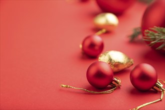 Christmas or New Year composition. Decorations, red balls, fir and spruce branches, on a red paper