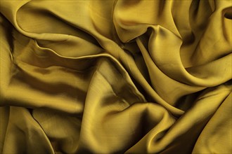 Fragment of yellow and green tissue. Side view, synthetic textile background and texture. wave