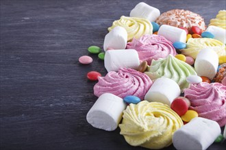 Mixed multicolored candies on black wooden background. copy space, top view, flat lay